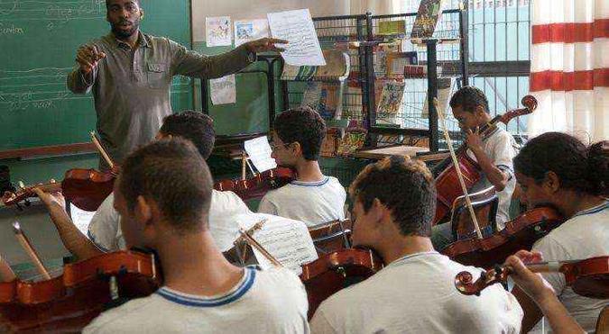 O ator Lázaro Ramos vive o maestro Silvio Baccarelli, ensinando música clássica para jovens da favela de Heliópolis(foto: Reprodução) O ator Lázaro Ramos vive o maestro Silvio Baccarelli, ensinando música clássica para jovens da favela de Heliópolis(foto: Reprodução)