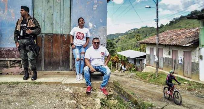 Policial mantém guarda ao lado de membros do partido Força Alternativa Revolucionária do Comum (Farc), em Monteloro, no Vale do Cauca(foto: Luis Robayo/AFP) Policial mantém guarda ao lado de membros do partido Força Alternativa Revolucionária do Comum (Farc), em Monteloro, no Vale do Cauca(foto: Luis Robayo/AFP)