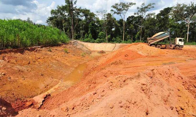 Caminhões depositam material na base da contenção, de onde água escoa (foto: Gladyston Rodrigues/EM/DA Press) Caminhões depositam material na base da contenção, de onde água escoa (foto: Gladyston Rodrigues/EM/DA Press)