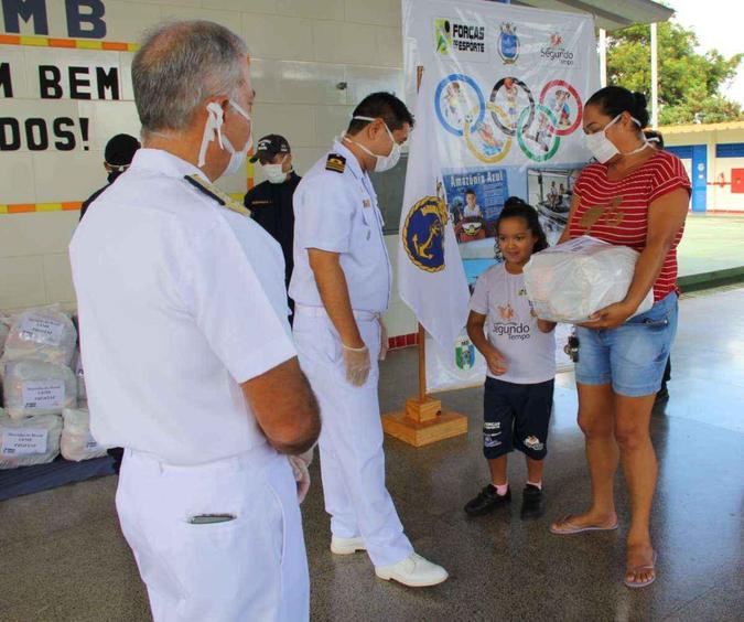Capitão de Fragata Hideki, Comandante da Estação Rádio da Marinha em Brasília, entrega um dos kits de alimentos(foto: Marinha do Brasil) Capitão de Fragata Hideki, Comandante da Estação Rádio da Marinha em Brasília, entrega um dos kits de alimentos(foto: Marinha do Brasil)