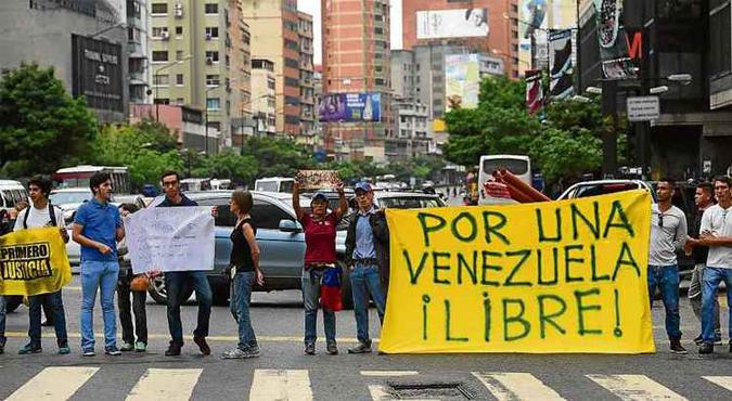 Manifestantes exibem faixa após bloquearem rua do centro de Caracas, durante ato contra o regime chavista: Manifestantes exibem faixa após bloquearem rua do centro de Caracas, durante ato contra o regime chavista: