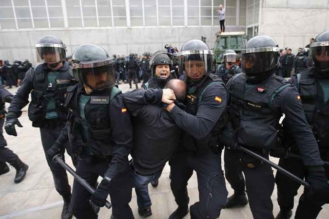 Na foto, um guarda espanhol arrasta um homem para fora de uma estação de voto em Sant Julia de Ramis, onde o presidente catalão deveria votar, no dia de um referendo sobre a independência da Catalunha banido por Madri(foto: Raymond Roig / AFP) Na foto, um guarda espanhol arrasta um homem para fora de uma estação de voto em Sant Julia de Ramis, onde o presidente catalão deveria votar, no dia de um referendo sobre a independência da Catalunha banido por Madri(foto: Raymond Roig / AFP)
