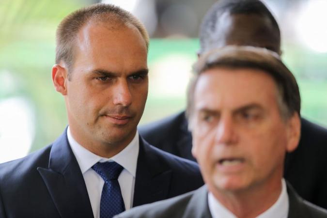 O presidente Jair Bolsonaro e o filho Eduardo ao fundo(foto: AFP) O presidente Jair Bolsonaro e o filho Eduardo ao fundo(foto: AFP)