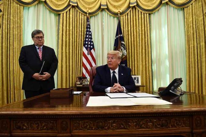 Acompanhado do procurador-geral, William Barr, Donald Trump é fotografado pouco antes de firmar o decreto: texto polêmico pode parar na Corte(foto: AFP / Brendan Smialowski) Acompanhado do procurador-geral, William Barr, Donald Trump é fotografado pouco antes de firmar o decreto: texto polêmico pode parar na Corte(foto: AFP / Brendan Smialowski)