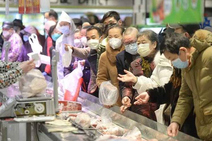 Com máscaras protetoras, moradores de Wuhan, onde surgiu a doença, fazem compras em mercado: China continental concentra 99% dos casos(foto: STR/AFP) Com máscaras protetoras, moradores de Wuhan, onde surgiu a doença, fazem compras em mercado: China continental concentra 99% dos casos(foto: STR/AFP)