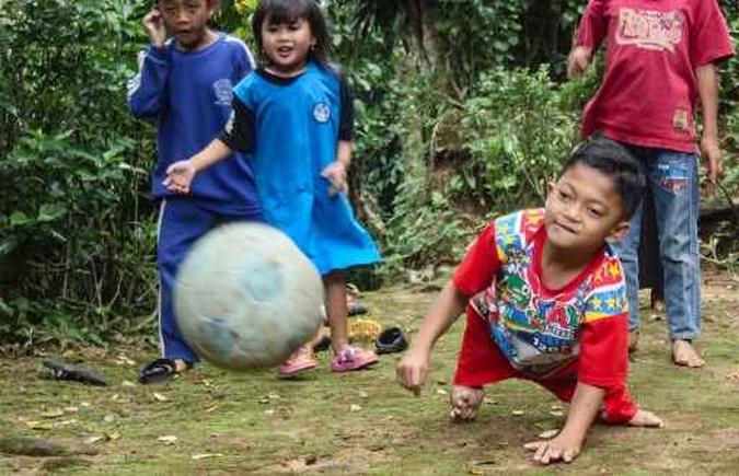 Mukhlis Abdul Holik, que não pode ficar de pé, percorre uma distância de cerca de seis quilômetros até a escola rastejando ou caminhando em suas mãos(foto: AFP) Mukhlis Abdul Holik, que não pode ficar de pé, percorre uma distância de cerca de seis quilômetros até a escola rastejando ou caminhando em suas mãos(foto: AFP)