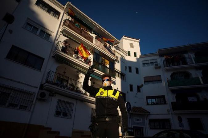 Um policial acena quando as pessoas aplaudem para agradecer aos profissionais de saúde que lidam com o coronavírus Covid-19 na Espanha.(foto: JORGE GUERRERO / AFP) Um policial acena quando as pessoas aplaudem para agradecer aos profissionais de saúde que lidam com o coronavírus Covid-19 na Espanha.(foto: JORGE GUERRERO / AFP)