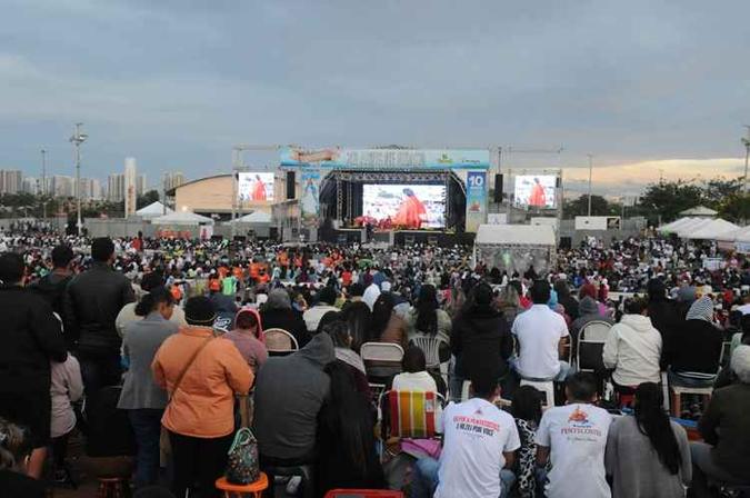 Muitos se sentam na grama ou ficam de pé para acompanhar a celebração(foto: Antonio Cunha/CB/D.A. Press) Muitos se sentam na grama ou ficam de pé para acompanhar a celebração(foto: Antonio Cunha/CB/D.A. Press)