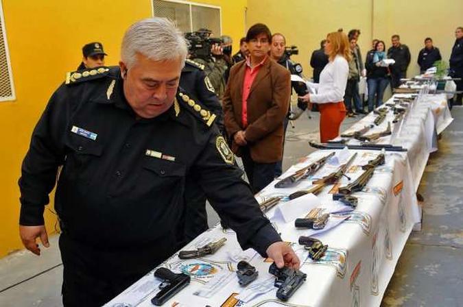 Policial exibe armas apreendidas em megaoperação contra o crime, na capital: (foto: AFP) Policial exibe armas apreendidas em megaoperação contra o crime, na capital: (foto: AFP)