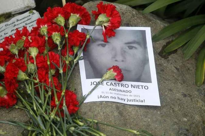 Pessoas colocam flores nos túmulos de pessoas mortas no golpe, durante a comemoração do 44º aniversário do golpe militar liderado pelo general Augusto Pinochet (foto: AFP / CLAUDIO REYES) Pessoas colocam flores nos túmulos de pessoas mortas no golpe, durante a comemoração do 44º aniversário do golpe militar liderado pelo general Augusto Pinochet (foto: AFP / CLAUDIO REYES)