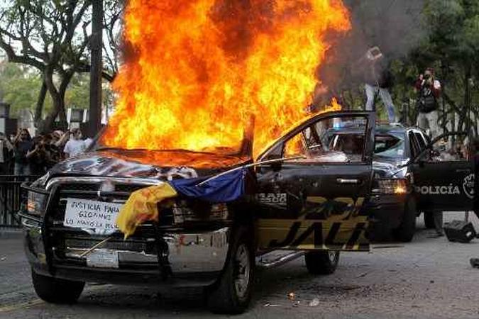 Manifestantes queimam veículos da polícia durante um protesto após a morte de um jovem sob custódia policial, depois de ele ter sido preso por não cumprir as medidas para impedir a propagação do coronavírus covid-19, em Guadalajara, estado de Jalisco, México.(foto: ULISES RUIZ / AFP) Manifestantes queimam veículos da polícia durante um protesto após a morte de um jovem sob custódia policial, depois de ele ter sido preso por não cumprir as medidas para impedir a propagação do coronavírus covid-19, em Guadalajara, estado de Jalisco, México.(foto: ULISES RUIZ / AFP)