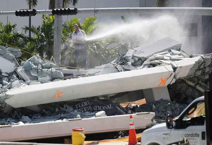 Vários veículos foram atingidos pelo desabamento da passarela de pedestres na Florida International University em Miami(foto: Joe Raedle/Getty Images/AFP) Vários veículos foram atingidos pelo desabamento da passarela de pedestres na Florida International University em Miami(foto: Joe Raedle/Getty Images/AFP)
