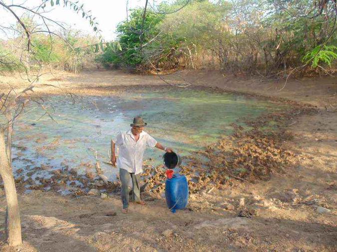 Agricultor aproveita últimos galões de água estagnada em açude: medida ampliará limite para atravessar a estiagem, mas pode trazer riscos, como o verificado em rompimento de represa na Bahia(foto: Luiz Ribeiro/Estado de Minas) Agricultor aproveita últimos galões de água estagnada em açude: medida ampliará limite para atravessar a estiagem, mas pode trazer riscos, como o verificado em rompimento de represa na Bahia(foto: Luiz Ribeiro/Estado de Minas)