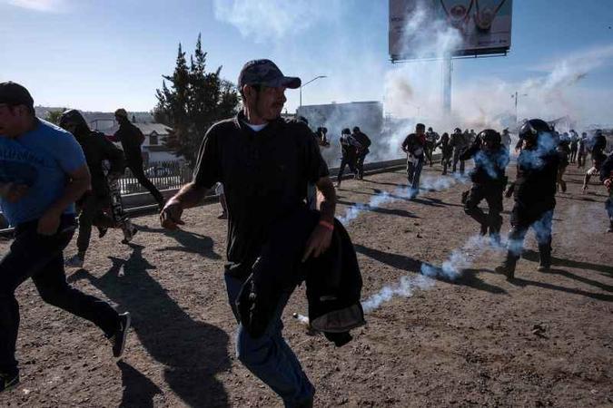 Após imigrantes tentaram romper a cerca que separa os EUA e o México nessa região, agentes americanos dispararam bombas de gás lacrimogêneo a fim de dispersar a multidão(foto: AFP/Guillermo Arias) Após imigrantes tentaram romper a cerca que separa os EUA e o México nessa região, agentes americanos dispararam bombas de gás lacrimogêneo a fim de dispersar a multidão(foto: AFP/Guillermo Arias)