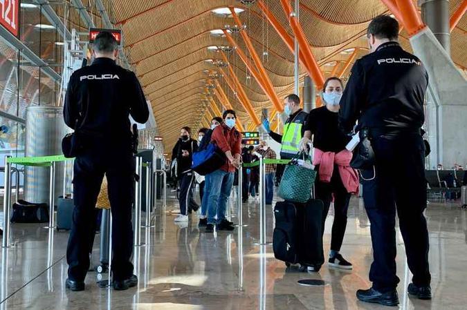 Policiais espanh�is conferem documentos de passageiros ap�s desembarque no aeroporto de Madri: Europa realiza abertura lenta para conter doen�a(foto: AFP / GABRIEL BOUYS)