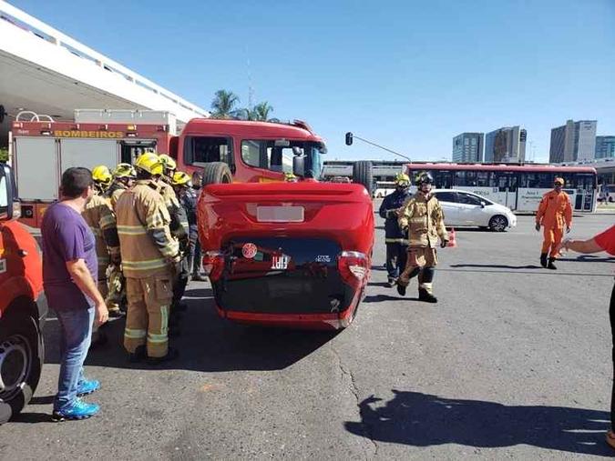 Após a colisão, o Fiat Mobi vermelho capotou na via (foto: Divulgação/CBMDF) Após a colisão, o Fiat Mobi vermelho capotou na via (foto: Divulgação/CBMDF)