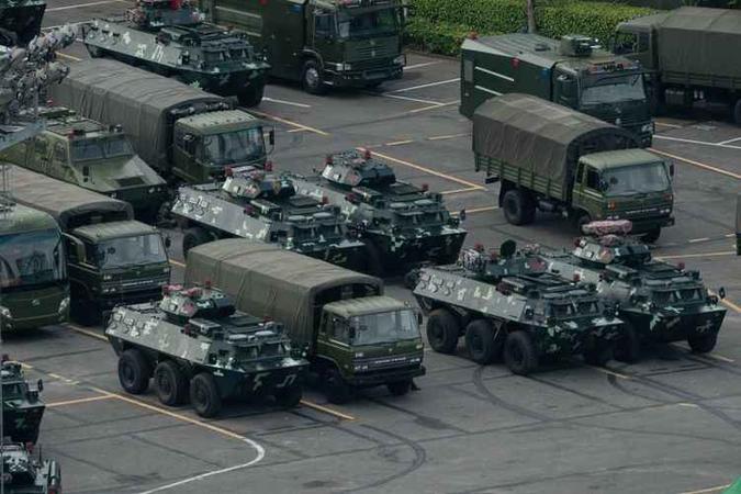 Tanques e caminhões militares da China estacionados a 27km da fronteira (foto: STR/AFP ) Tanques e caminhões militares da China estacionados a 27km da fronteira (foto: STR/AFP )