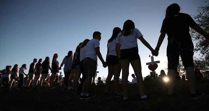 Jovens dão as mãos em enterro das vítimas do massacre da escola em Parkland(foto: MARK WILSON / GETTY IMAGES NORTH AMERICA / AFP) Jovens dão as mãos em enterro das vítimas do massacre da escola em Parkland(foto: MARK WILSON / GETTY IMAGES NORTH AMERICA / AFP)